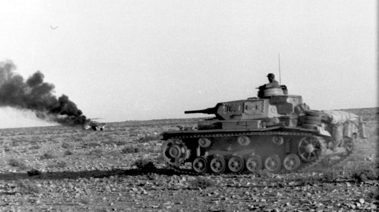A German tank advances in the desert.